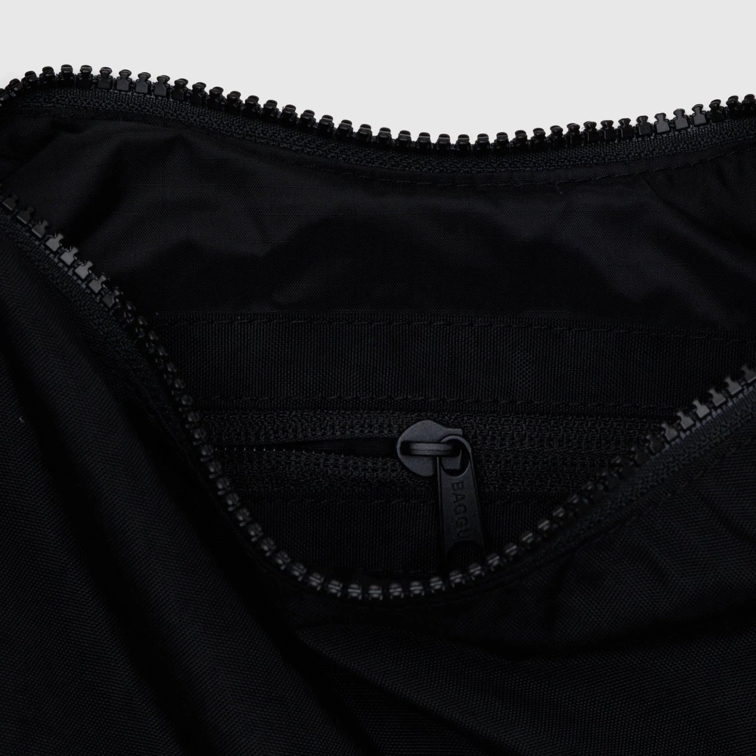 Black nylon crescent bag interior with zippered pocket and zipper pull