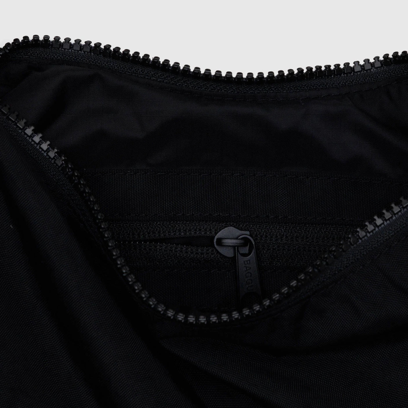 Black nylon crescent bag interior with zippered pocket and zipper pull