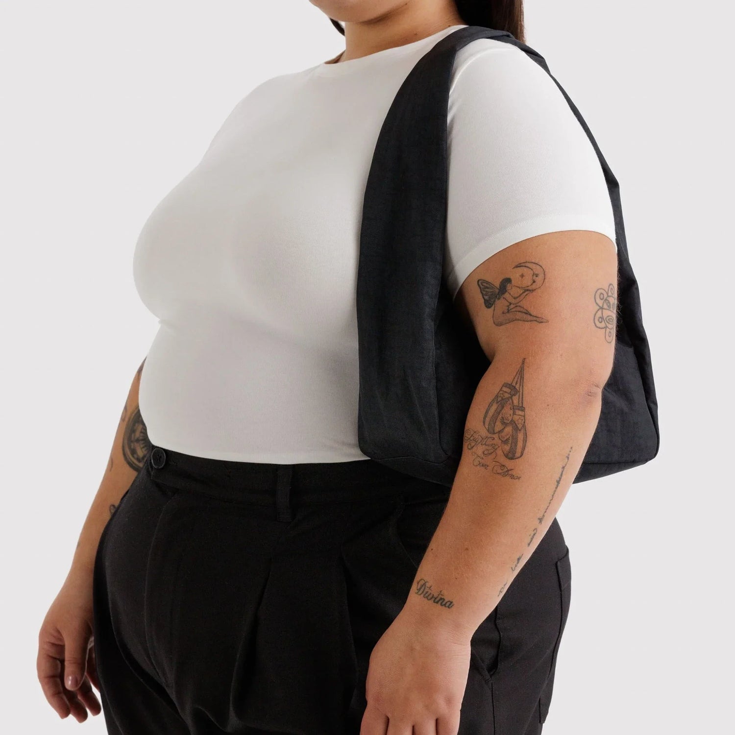 Black nylon small shoulder bag worn on one shoulder, open top design
