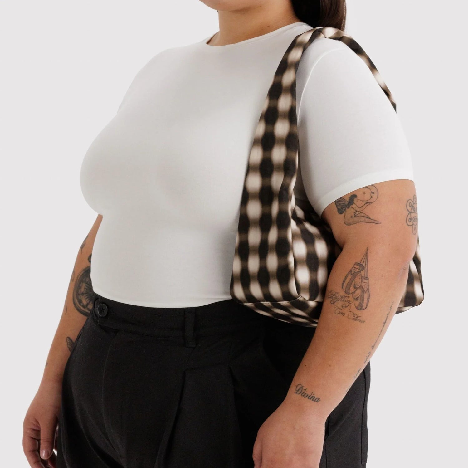 Small nylon shoulder bag with blurred brown gingham, worn on shoulder