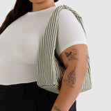 Small striped nylon hobo bag worn on shoulder, sage green and white vertical stripes
