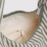 Nylon bag interior with beige lining and silver zipper pull, sage and white striped trim