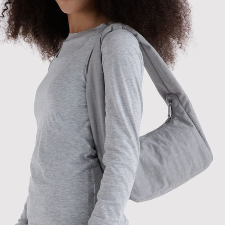Small fog gray nylon tote bag worn on shoulder with front zipper pocket