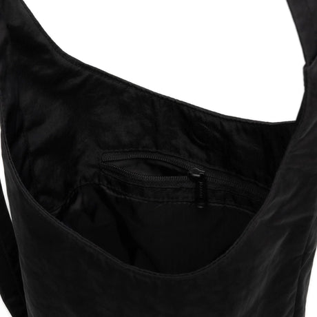 Close-up of the stylish Baggu Small Nylon Sling - Black, crafted from durable nylon, showcasing its interior with a zippered pocket.