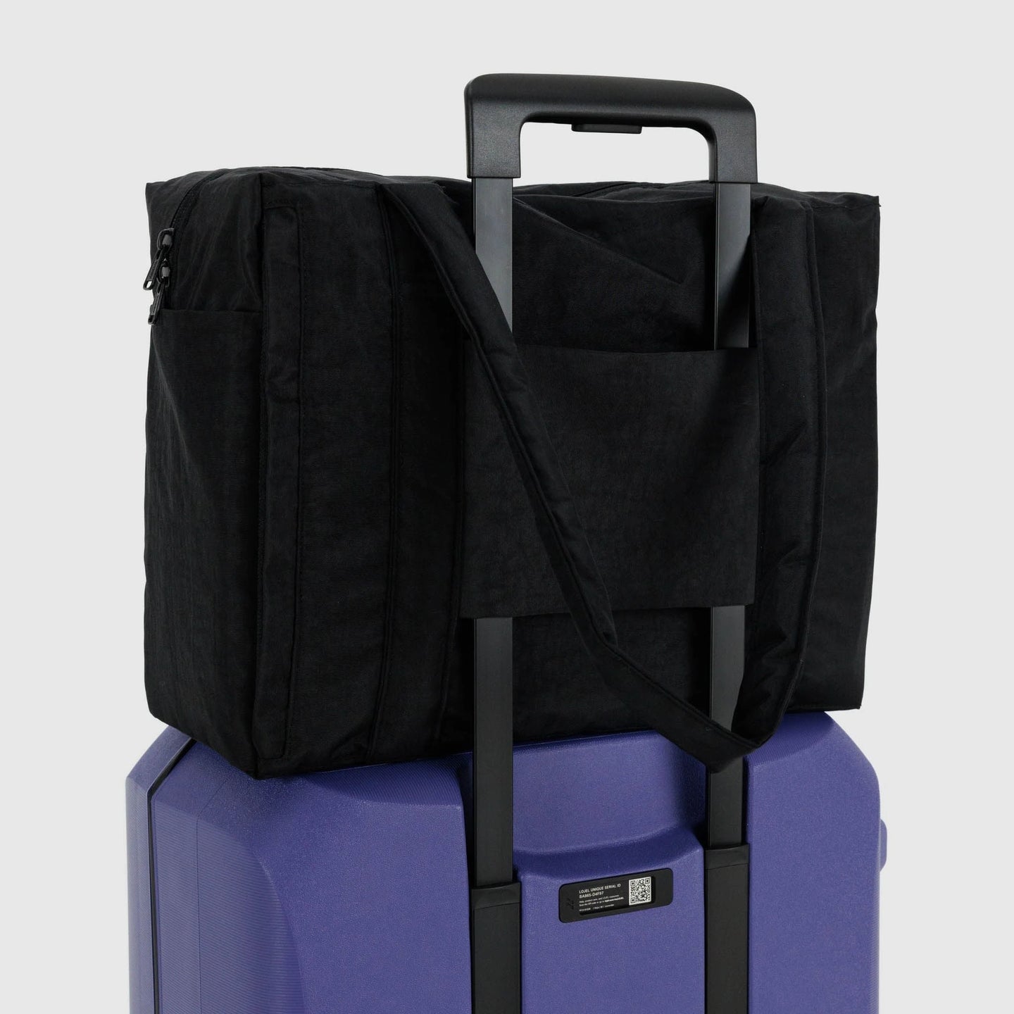 Black carry-on bag with handle sleeve and zippered side panels