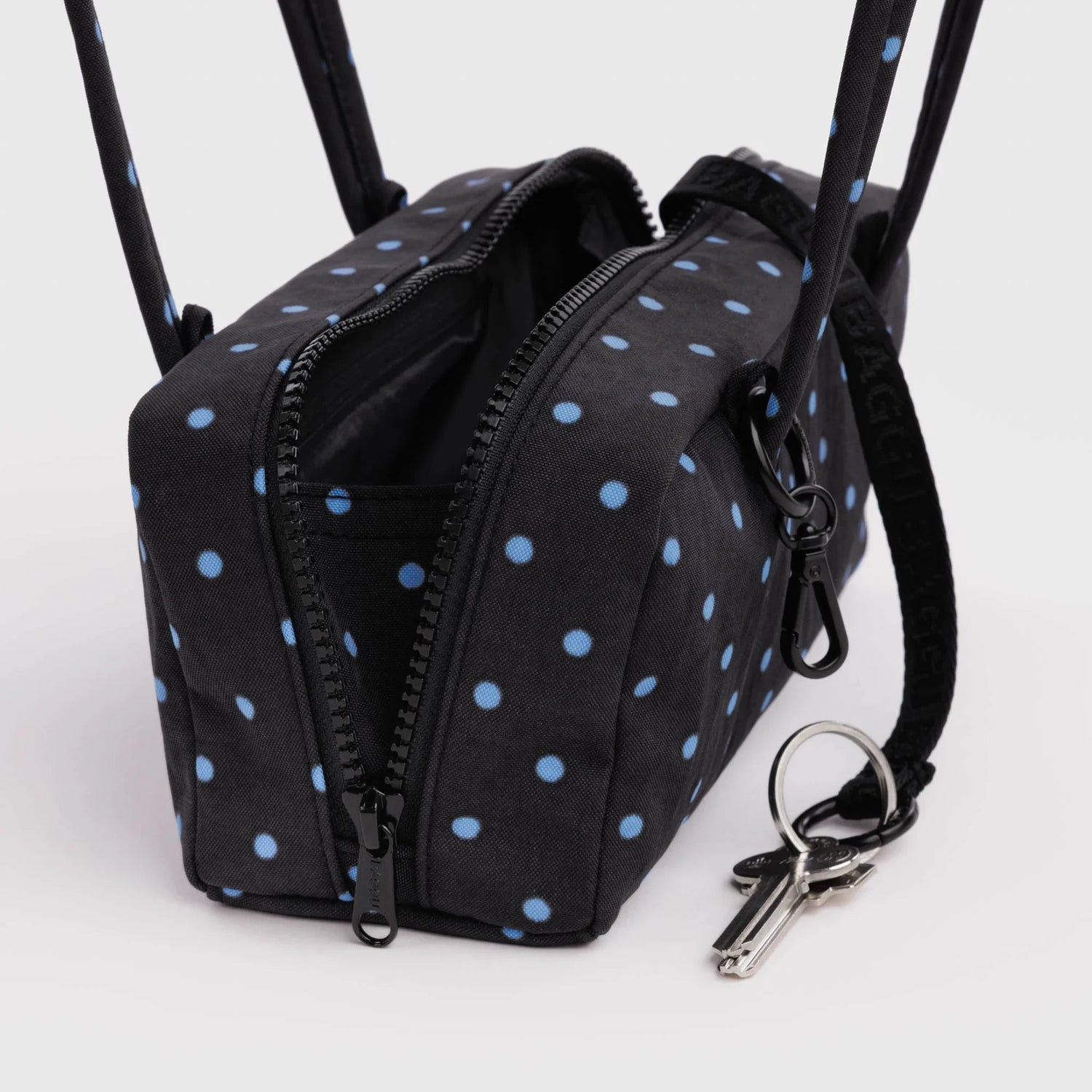Small bowler bag with micro dot fabric, front zip pockets, key ring and strap details
