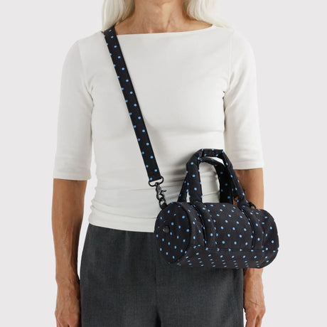Small nylon duffle bag worn crossbody with long strap, blue micro-dot print
