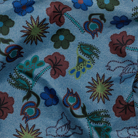 Digital Denim Birds fabric featuring a floral pattern in red, green, and blue with stylized flowers and leaves, crafted from recycled nylon yarn by Baggu.