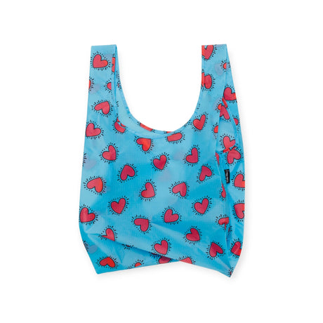 A bag from the Keith Haring x Baggu Set of 3 Standard Bags by Baggu, made from recycled nylon in blue and adorned with a striking red heart pattern reminiscent of Keith Haring's iconic style.