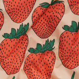 Close-up of strawberry pattern fabric with red fruit shapes and green leaves