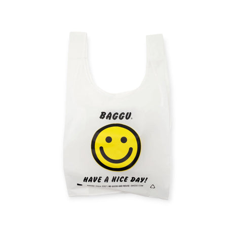 The Baggu Standard Reusable Bag - Thank You Happy, designed by Baggu, is a white shopping bag made from recycled nylon. It features the text "BAGGU. Have a nice day" and showcases a large yellow smiley face. Known for its large capacity, this eco-friendly bag is perfect for any outing.