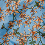 The Big Baggu Bag - Orchid by Baggu features a stunning eco-friendly design with orange and cream flowers and green stems on a light blue background.