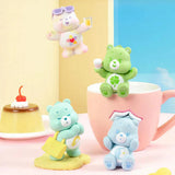 Playful bear mini figures on tabletop with pastel teacup and cake pieces.