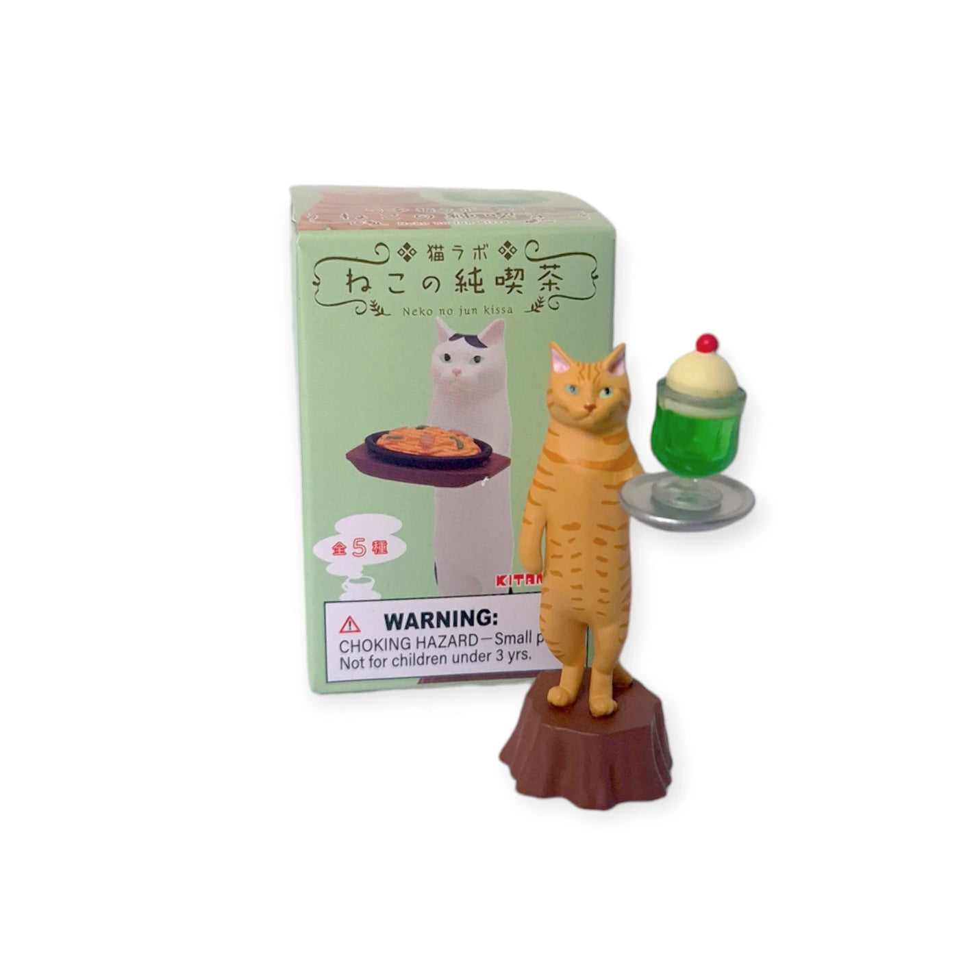 A charming Cat Cafe Waiter toy figure from Mofusand, featuring a waiter holding a green dessert with cream, is packaged alongside its box displaying matching artwork and a caution regarding small parts. This delightful item adds an element of mystery and excitement by being part of the Cat Cafe Waiter Blind Box collection.