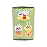 The Chiikawa Food Keychain Blind Box by Yell includes three cute cartoon animal toys dressed in foodie costumes: one sits on rice, another rests on a cream bun, and there's a rabbit relaxing on pizza. Japanese text above each character adds an extra touch of charm, making it an ideal collectible.