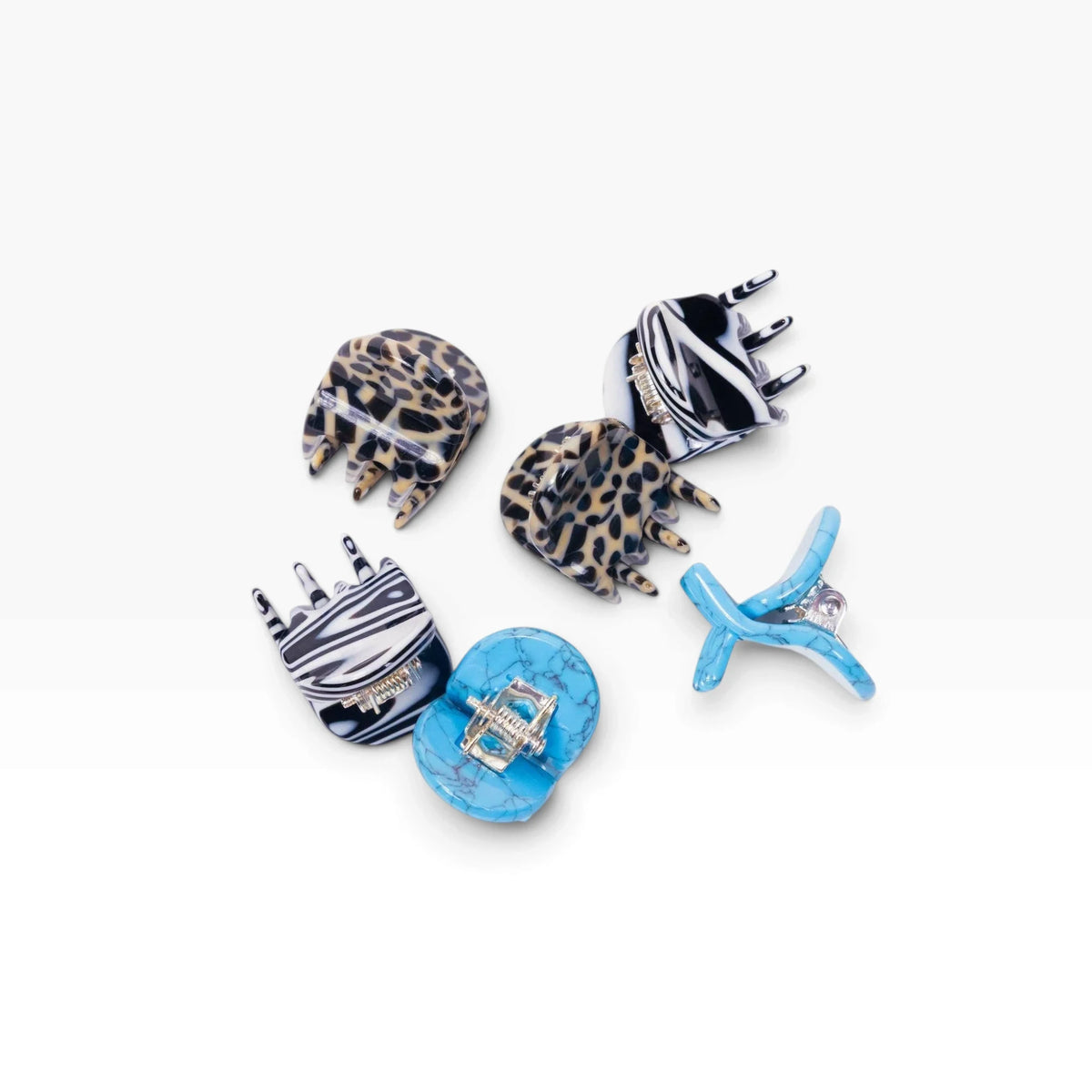 Five micro claw hair clips with zebra, leopard, and blue designs, grouped together.