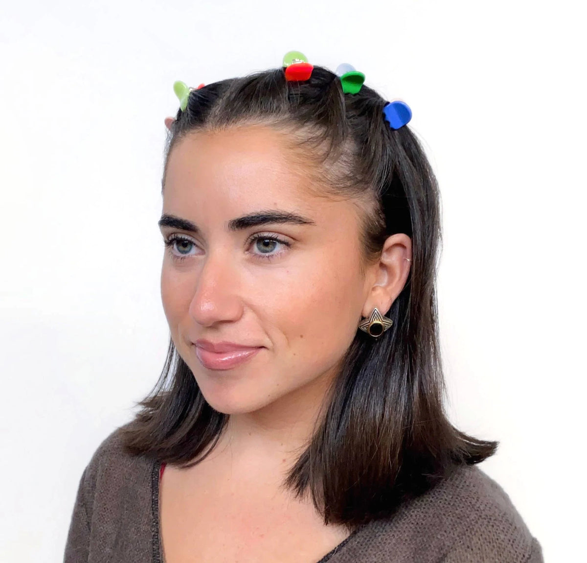 Micro claw hair clips on dark hair, multicolor red, green, and blue