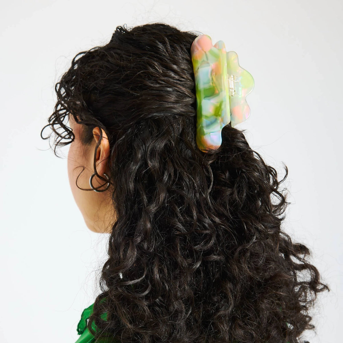 Sherbet jelly translucent claw clip securing curly black hair at the back