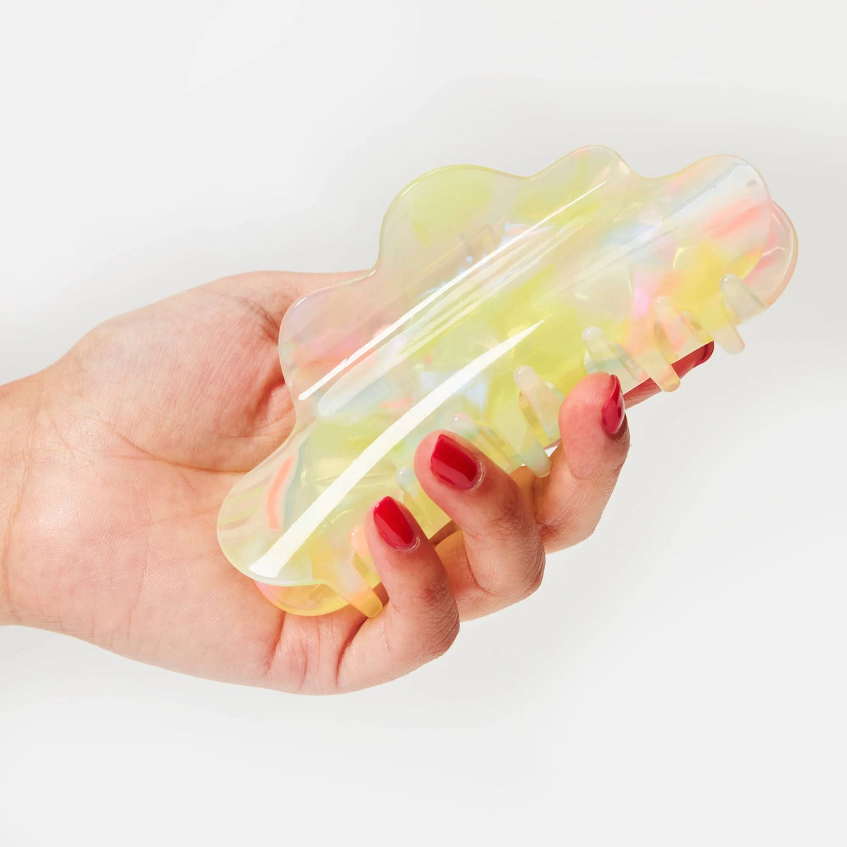 Translucent sherbet jelly claw clip held in hand, pastel rainbow glow