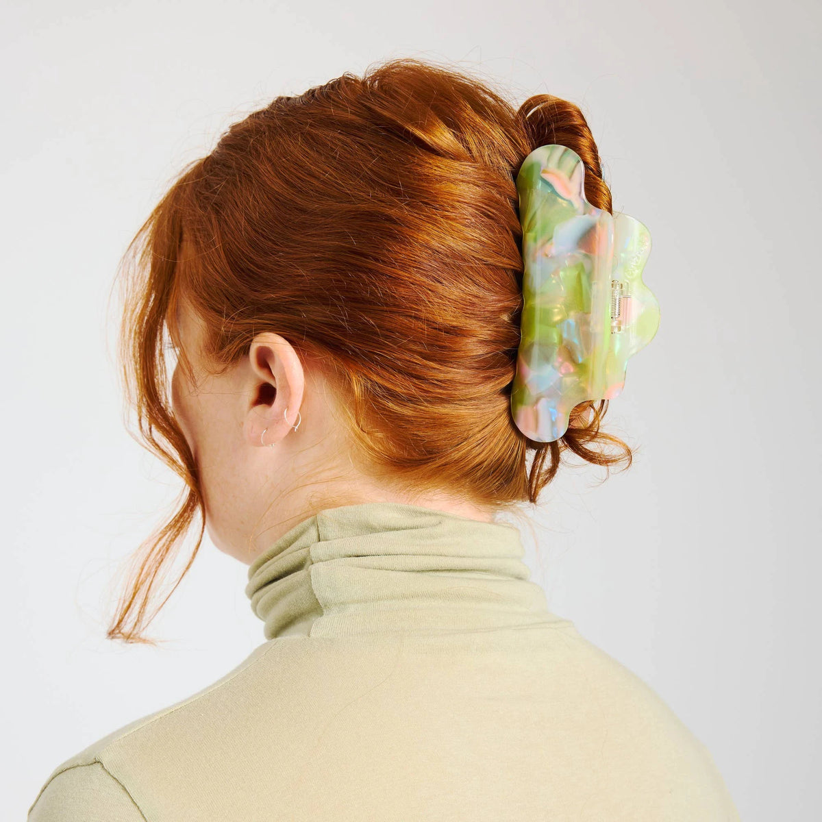 Pastel sherbet translucent claw clip on dark brown hair in a low bun
