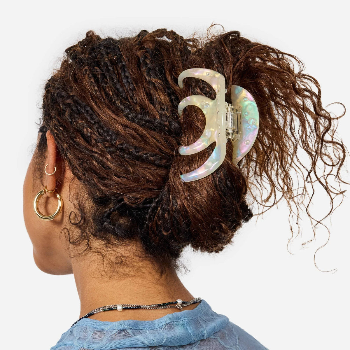 Large iridescent octopus-claw hair clip on curly brown hair