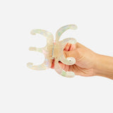 Iridescent octopus-claw hair clip with metal spring, prongs shown in hand