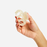 Small octopus claw hair clip close-up, translucent pearl-shimmer cream.