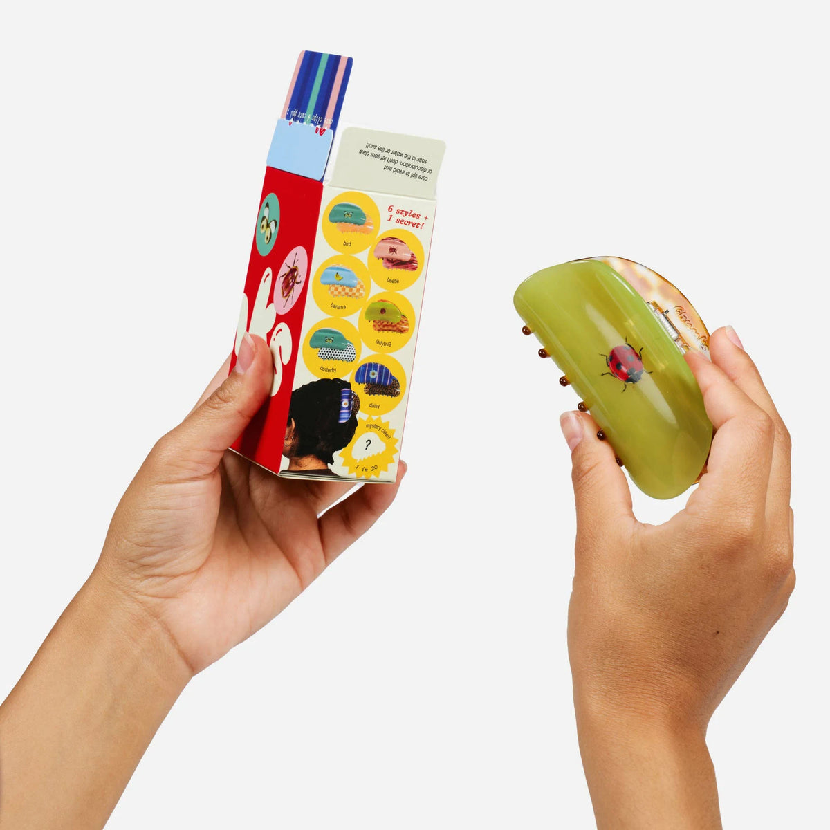 Hair claw clip blind box and green translucent claw clip held in hands