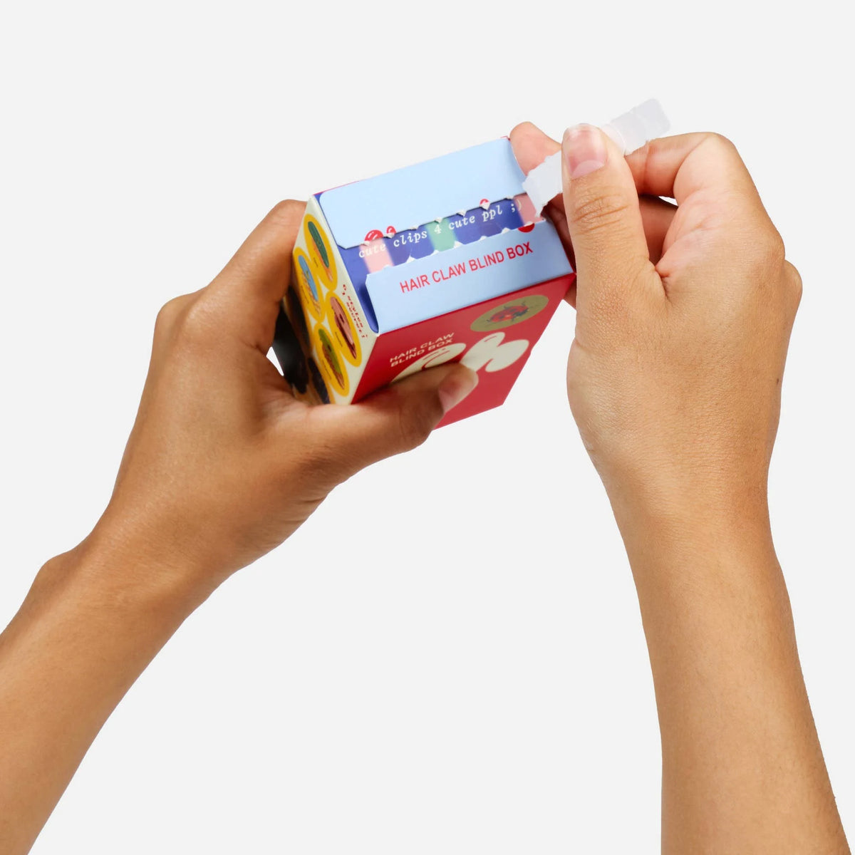 Hair claw clip blind box packaging held in hands, red and blue printed box