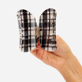 Black-and-white plaid claw clip open view, visible hinge and ridged teeth