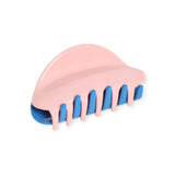 Pink chunky claw hair clip with blue ridged teeth, glossy finish.