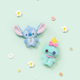 Two small plush character charms, blue and teal, with button accents and embroidered faces.