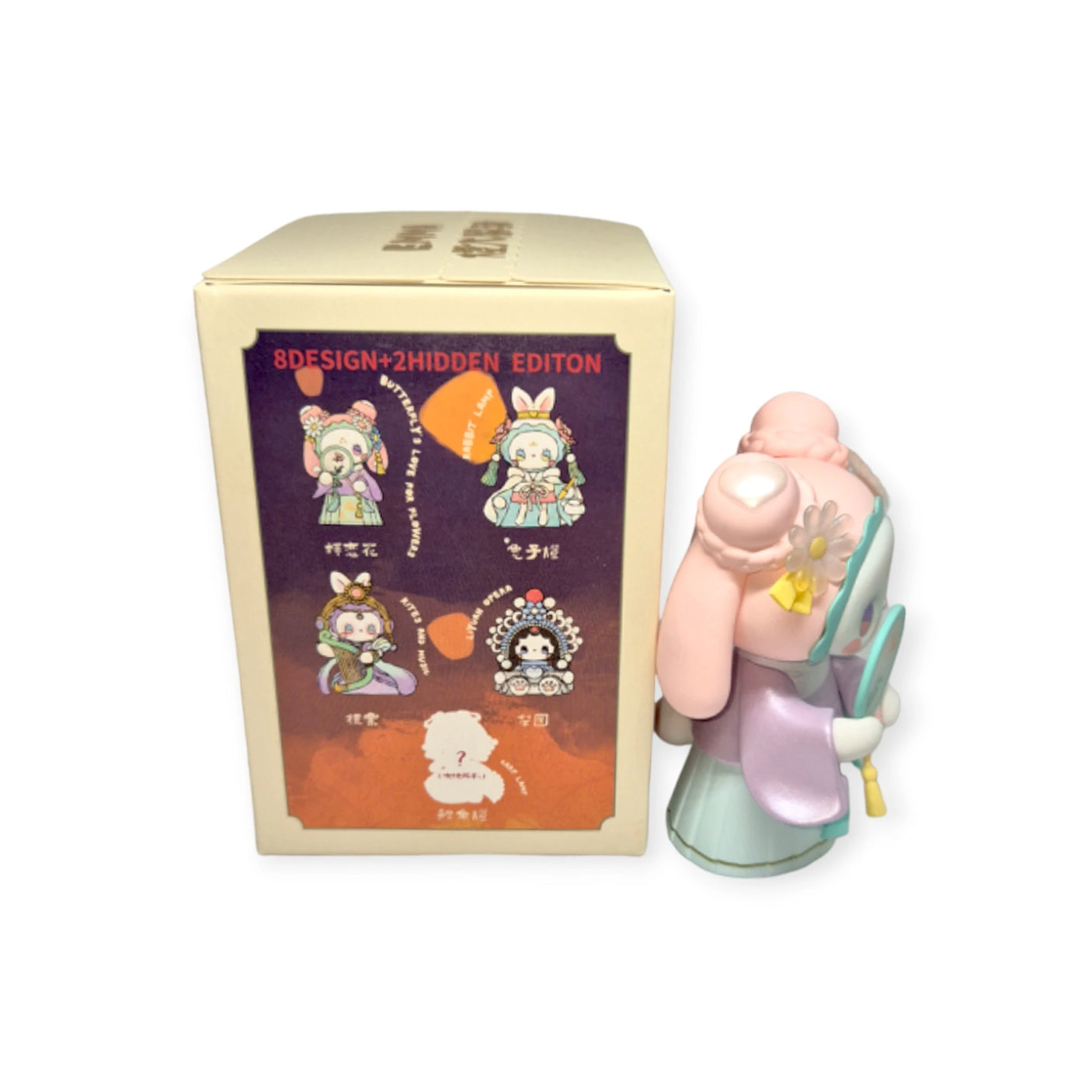 The Lucky EMMA - Secret Forest of Dim Lights Series Blind Box by Lucky Emma features whimsical character designs, including a pastel-colored figure accompanied by a broom, evoking the charm of a Secret Forest adventure.