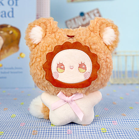 The Emma Fuzzy Family Keychain Blind Box by Lucky Emma features a plush toy with a lion-like face, round ears, and a pink ribbon—perfect as a cute keychain or bag charm.