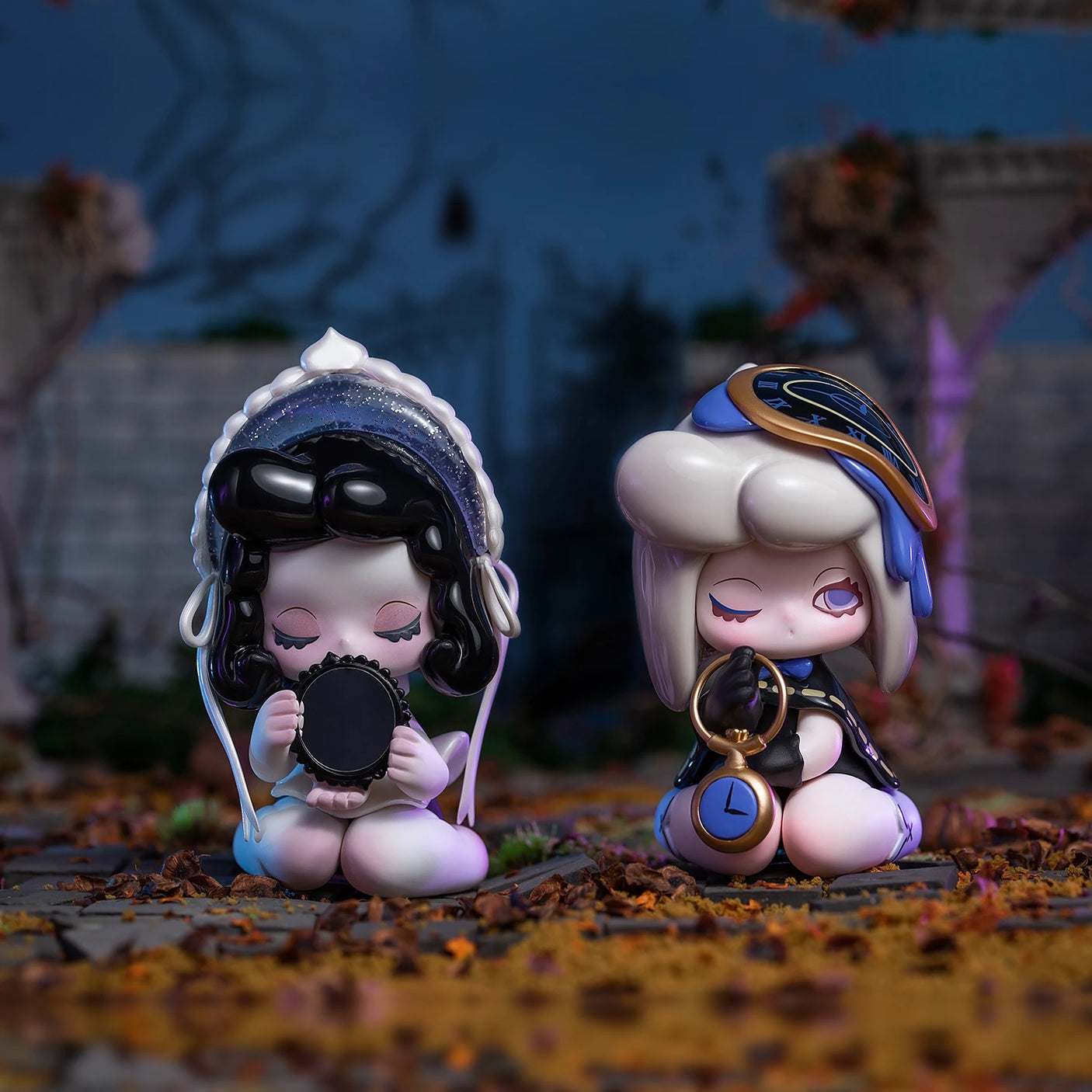 Amidst a path strewn with autumn leaves and branches, two stylized figurines from the 'Lucky EMMA - Killa Treasure Pavilion Blind Box' by Lucky Emma are seated with closed eyes. One figurine holds a mirror while the other holds a clock, as if safeguarding Secret Treasures. In this blurred and dark outdoor scene, they evoke the mystical aura of the Killa Treasure Pavilion.