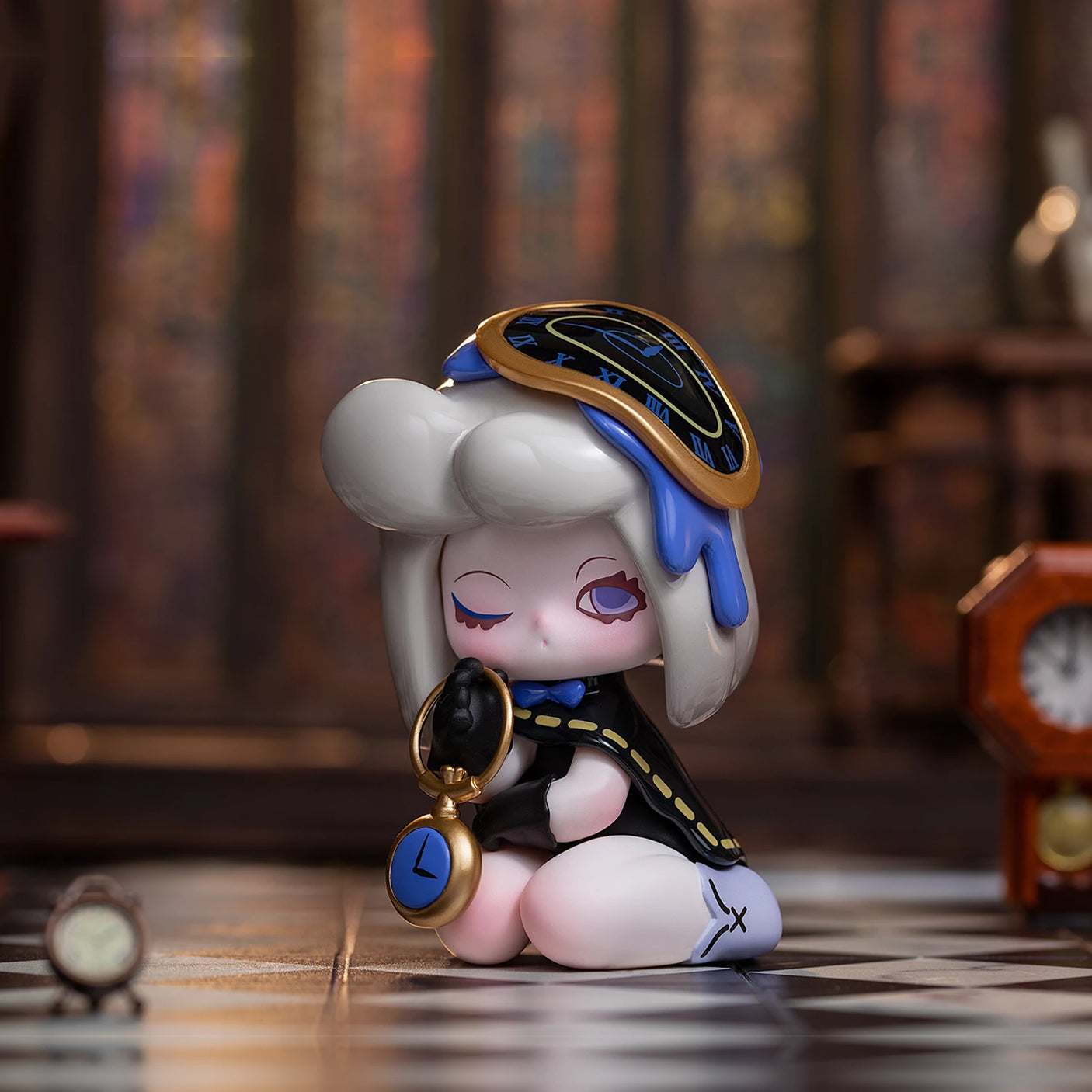 The Lucky EMMA from the Killa Treasure Pavilion Blind Box collection by Lucky Emma is a small figurine with a clock-themed design. It features closed eyes and holds a stopwatch, seated on a checkered surface adorned with miniature clocks that evoke the mystique of Secret Treasures.