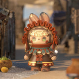 A vibrant, cartoon-style figurine from the Lucky EMMA - Secret Forest River of Time Blind Box collection by Lucky Emma is set in a rustic environment, adorned with a headpiece and decorative attire. A woven basket filled with fruit sits close by.