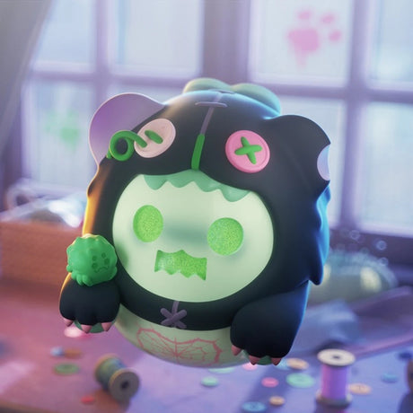 Black and pastel green ShinWoo Ghost Bear collectible figure with button eyes and holding a green spiky ball on blurred background