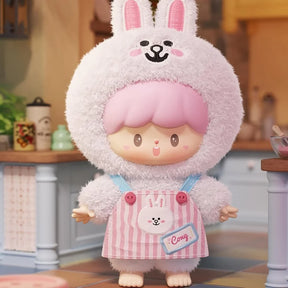 Soft plush figure dressed in a fuzzy bunny outfit with pink striped overalls and a cute expression standing indoors