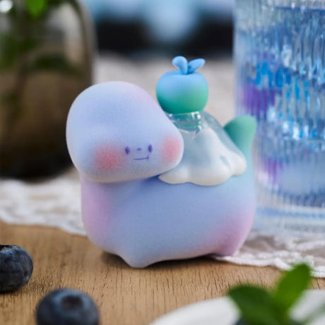 Pastel blue-purple Food Dinosaur Fuji Yama Vol. 2 figure with green fruit and white frosting on wooden table close-up