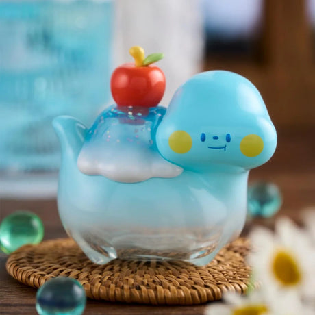 Translucent blue Food Dinosaur Fuji Yama Vol. 2 figure with syrup and red apple on a woven coaster close-up