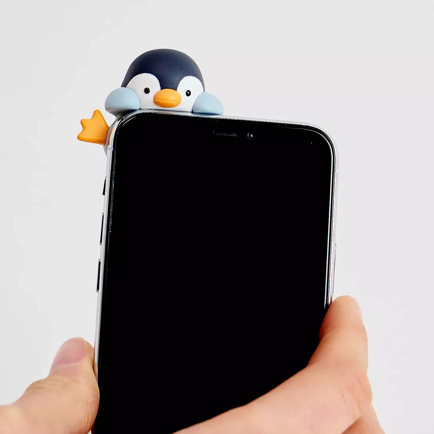Phone case with penguin-shaped charm on the back