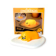 The Gudetama 3D Squishy Silicone Night Light, fondly called the Lazy Egg, boasts a soft silicone design on a white base. It sits before its packaging, highlighting the whimsical product and "Gudetama" brand name.