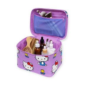 A Hello Kitty x Baggu Large Cosmetic Case by Baggu, in purple, sits open to show neatly organized hairbrushes, bottles, and makeup brushes inside.