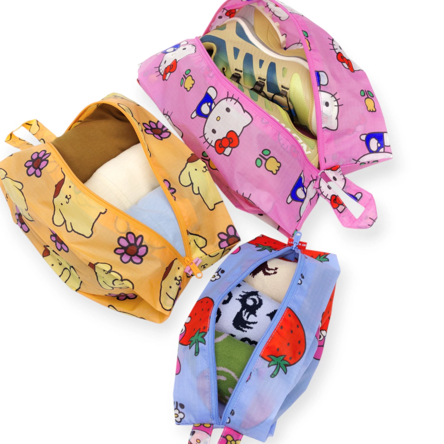 The Hello Kitty x Baggu Storage & Travel Set by Baggu features three zippered pouches with cute Hello Kitty, Pompompurin, and strawberry prints—ideal for stylishly organizing clothes or shoes when you travel.