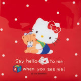 Hello Kitty with a teddy bear on a red polka-dot background in charming Sanrio style. The text says, "Say hello to me when you see me!" Ideal for fans of the Retro Hello Kitty Red Wallet by Hello Kitty, offering a nostalgic, vintage design.