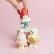 Red mushroom-style animal figurine held in hand with two matching figures