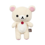 The Korilakkuma Small Plush - 20cm by Rilakkuma is a beige bear with pink ears, black eyes, a red chest button, and a “Rilakkuma” side tag, standing upright against a white background.