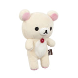 The Korilakkuma Small Plush - 20cm by Rilakkuma features beige fur, pink ears, black eyes, and a red chest button. Standing upright with a "Rilakkuma" side tag, it showcases premium softness and playful charm.