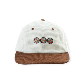 White ribbed baseball cap with brown brim and three multicolor donut patches